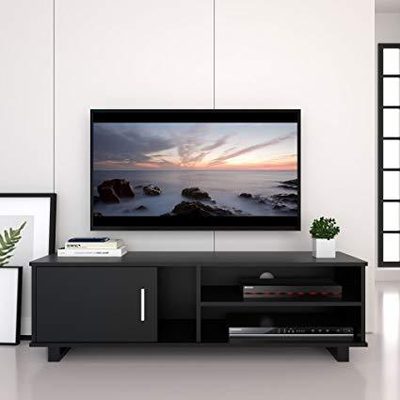 Flat-screen TV and soundbar mounted flush on a concrete feature wall above a low white media unit